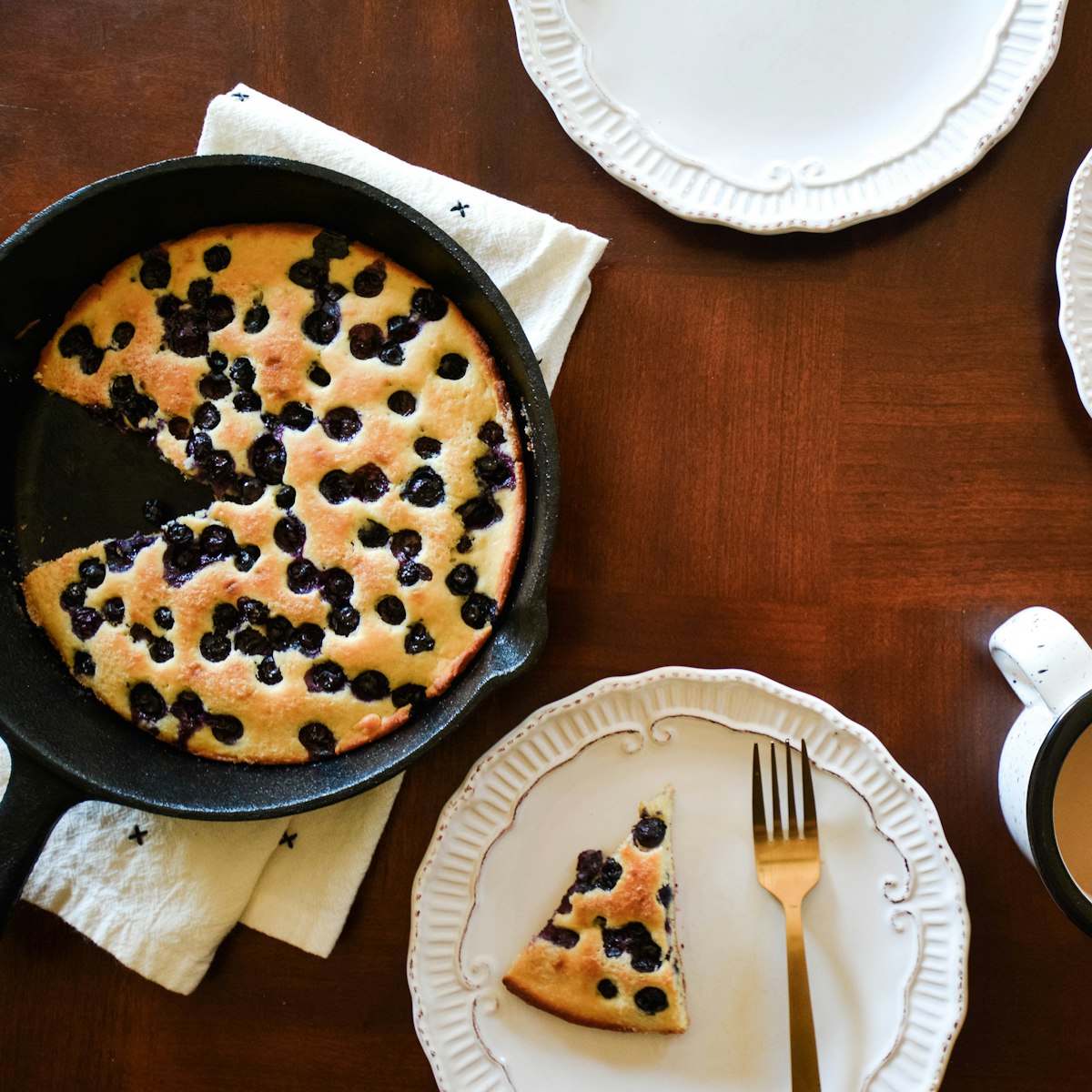 Top view of a blueberry skillet cake baked in cast iron on a rustic table